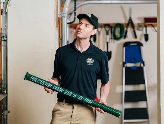 Technician holding a replacement garage door spring